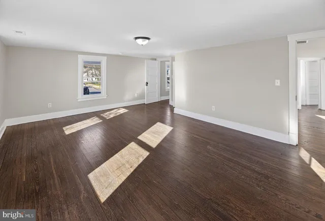 a view of a room with wooden floor and window