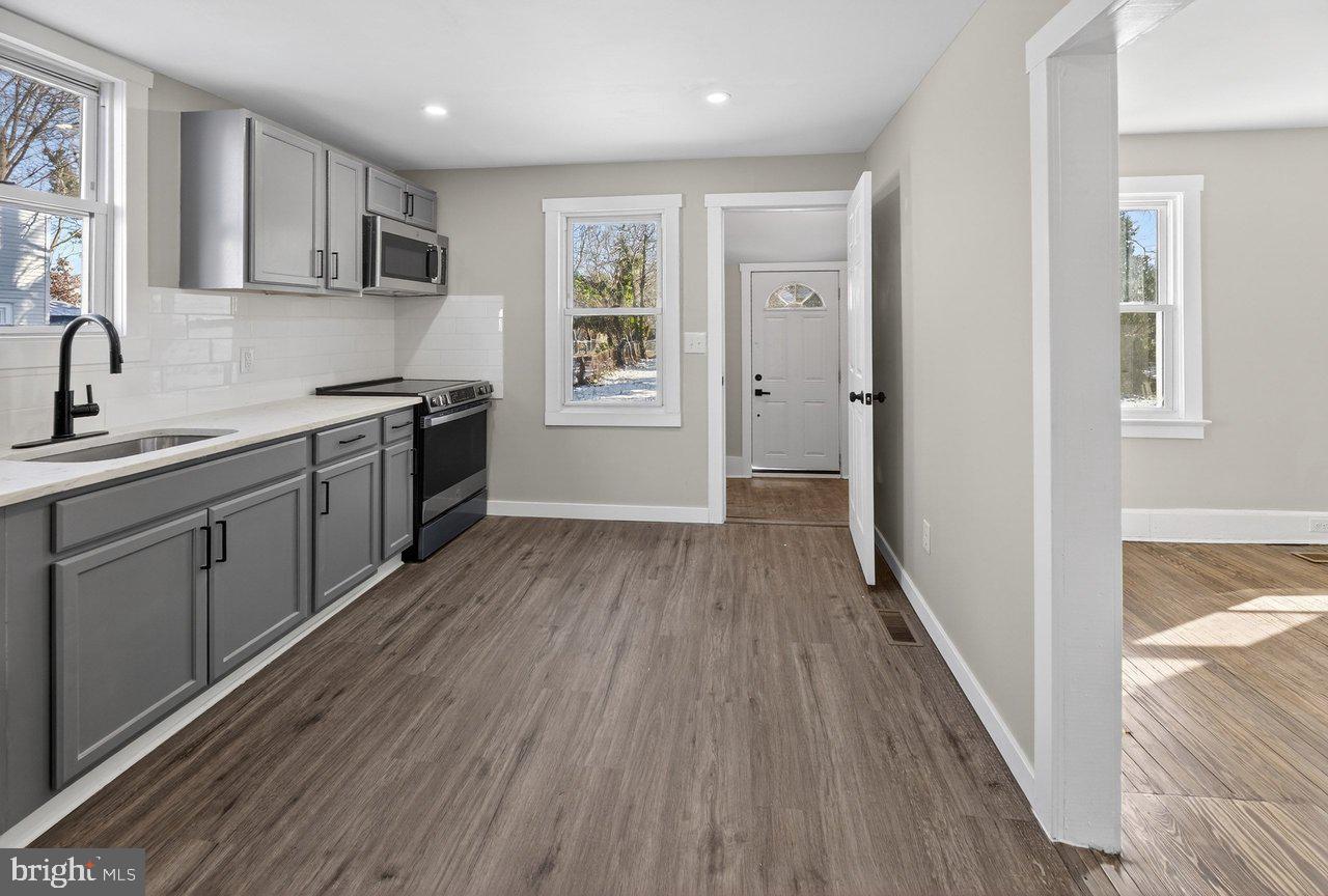 26 Olive Street Salem, NJ 08079 - Photo 7 of 33 a kitchen with stainless steel appliances granite countertop a refrigerator a sink dishwasher a stove and white countertops with wooden floor