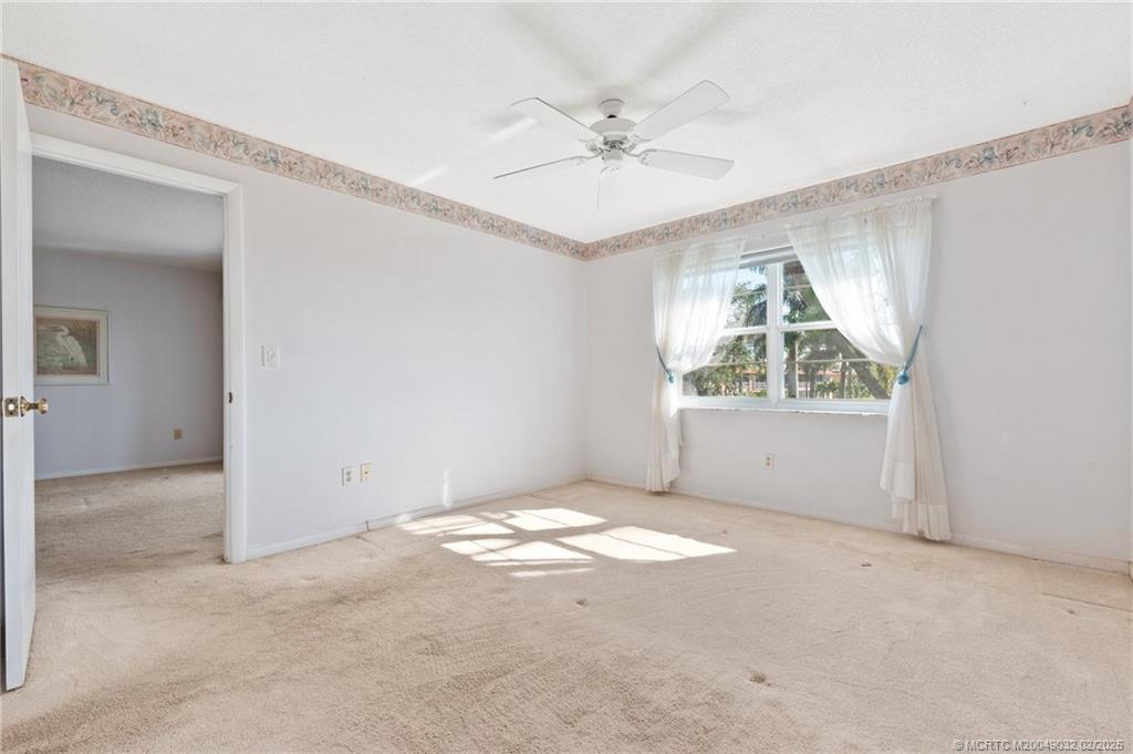 1907 Southwest Palm City Road, Unit 4J Stuart, FL 34994 - Photo 13 of 34 an empty room with windows and fan
