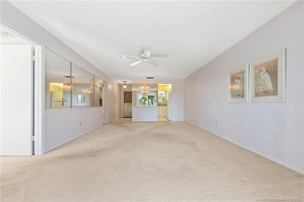 1907 Southwest Palm City Road, Unit 4J Stuart, FL 34994 - Photo 7 of 34 an empty room with windows and ceiling fan