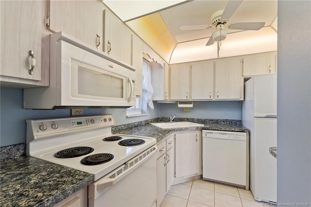 1907 Southwest Palm City Road, Unit 4J Stuart, FL 34994 - Photo 9 of 34 a kitchen with a sink a stove and cabinets