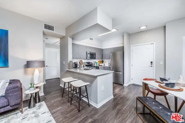 a kitchen with a dining table chairs and refrigerator