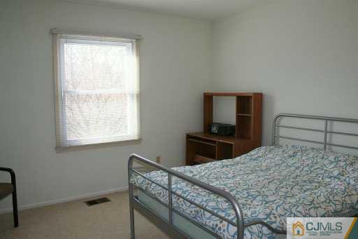 82 La Rue Lane East Brunswick, NJ 08816 - Photo 5 of 5 a bedroom with a bed and a flat screen tv