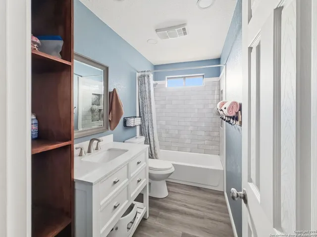 a bathroom with a sink a toilet a mirror and shower