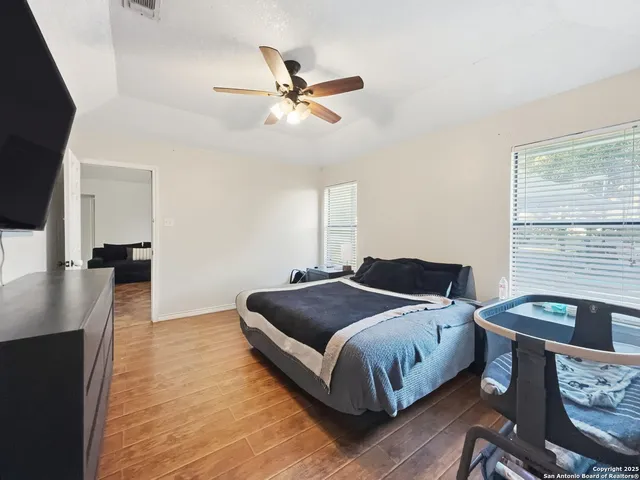 a living room with a bed furniture and a flat screen tv