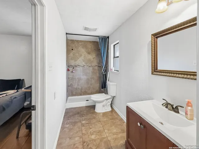 a bathroom with a sink a toilet and shower