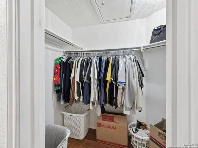 a view of walk in closet with clothes and shoes