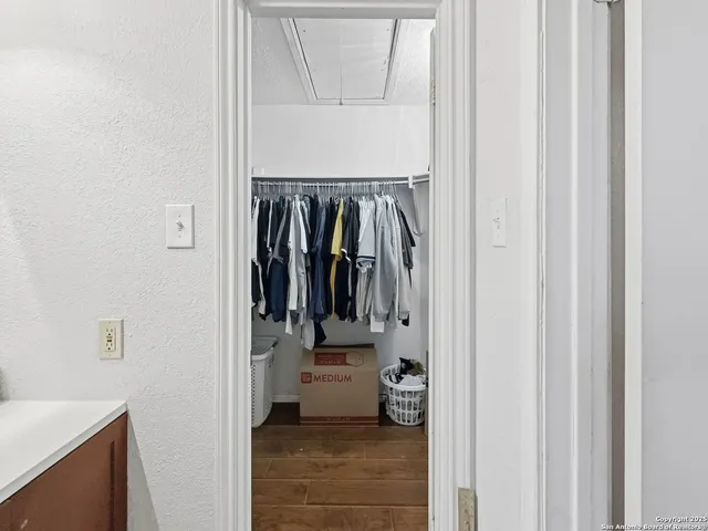 a view of walk in closet with clothes and shoes