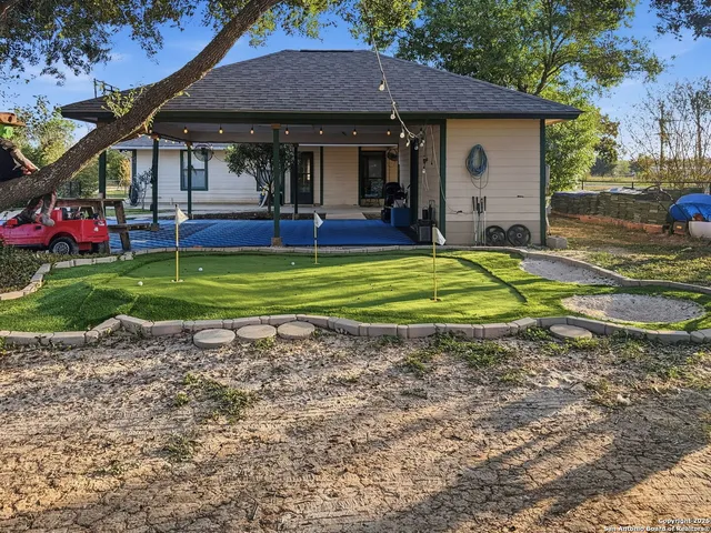 a view of a house with backyard and trees