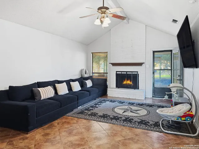 a living room with furniture a fireplace and a flat screen tv