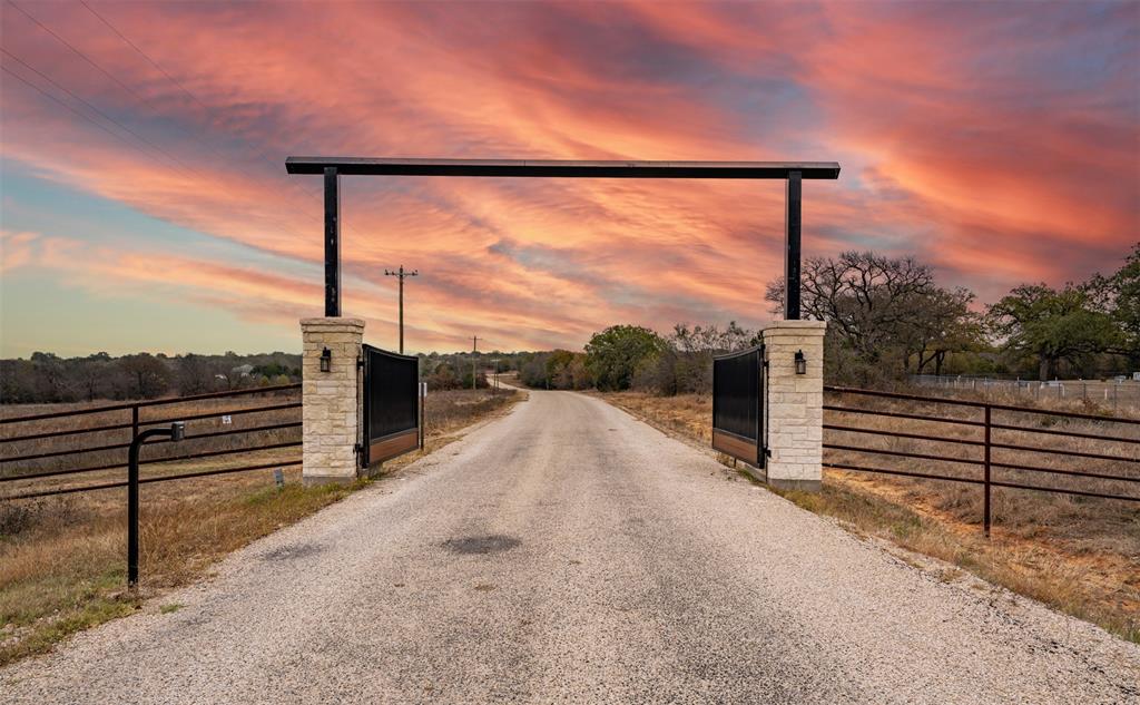 View of dirt / gravel road featuring a gate and a gated entry