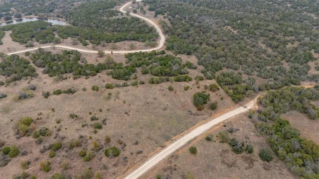 a view of a dry yard with wooden fence