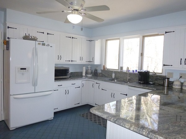 27 Westcott Road Harvard, MA 01451 - Photo 15 of 30 a large white kitchen with granite countertop a stove a sink a refrigerator and white cabinets with wooden floor