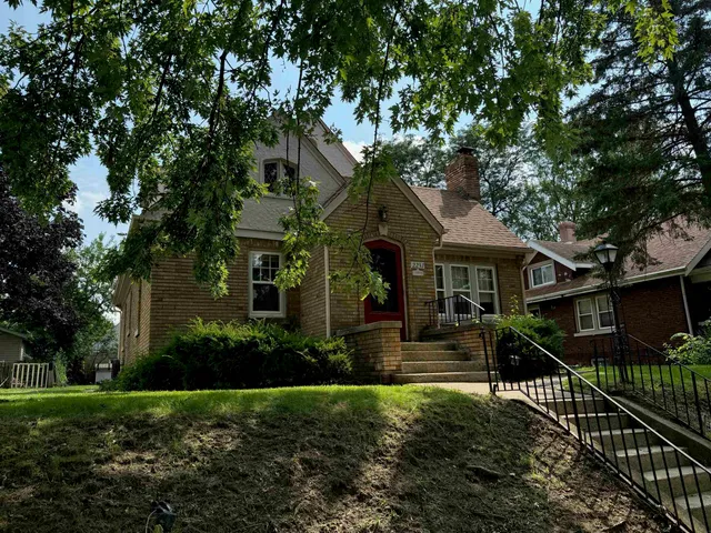 a front view of a house with yard and green space
