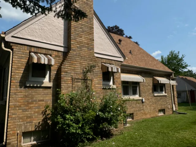 a front view of a house with a yard and trees