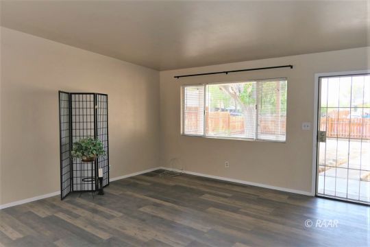 744 West Reeves Avenue Ridgecrest, CA 93555 - Photo 4 of 26 an empty room with wooden floor and windows