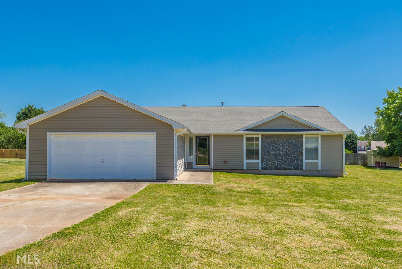 a front view of house with yard and garage