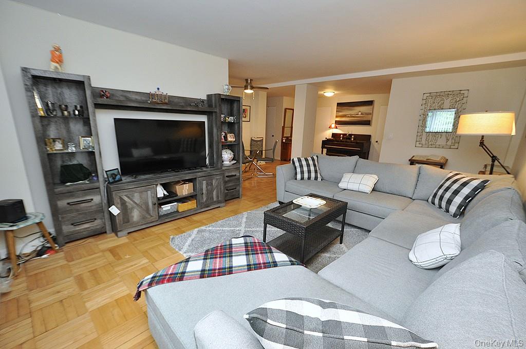 235 Garth Road, Unit A5B Scarsdale, NY 10583 - Photo 4 of 47 a living room with furniture and a flat screen tv