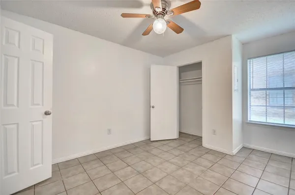 an empty room with closet and windows