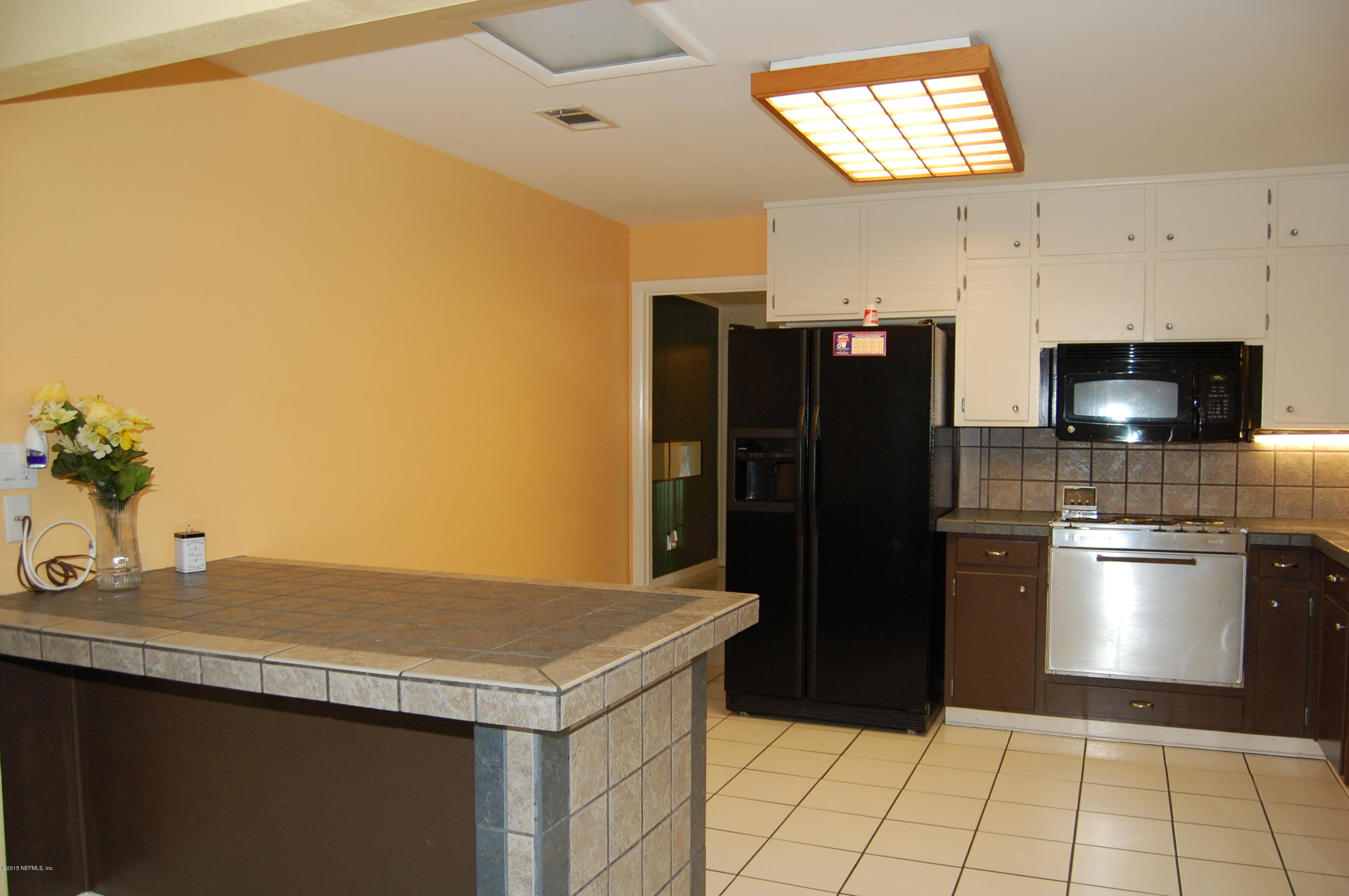 3734 Gurley Road Jacksonville, FL 32277 - Photo 12 of 38 a kitchen with a refrigerator and a sink