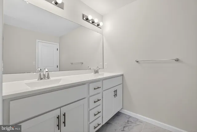 a spacious bathroom with a double vanity sink and a mirror
