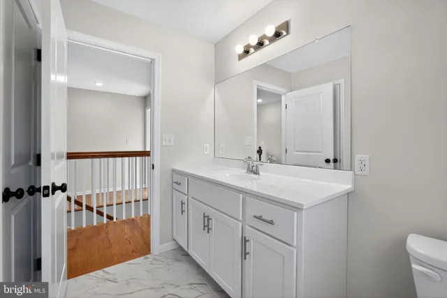 a bathroom with a double vanity sink toilet and mirror