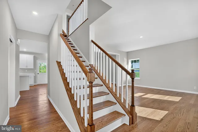 a view of staircase with wooden floor and a chandelier