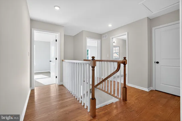 a view of a hallway with wooden floor and closet