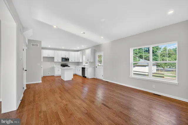 a view of a kitchen and window with wooden floor