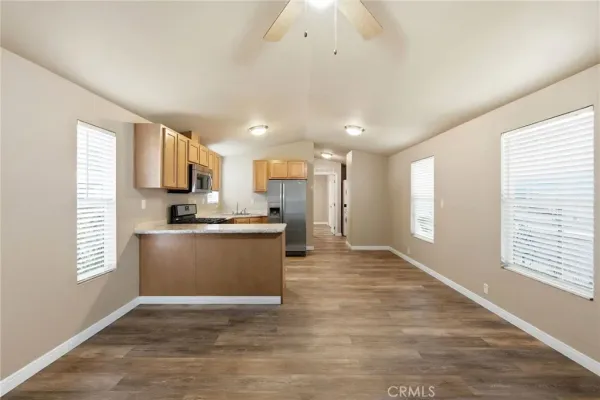 a view of kitchen with kitchen island a sink wooden floor and a refrigerator