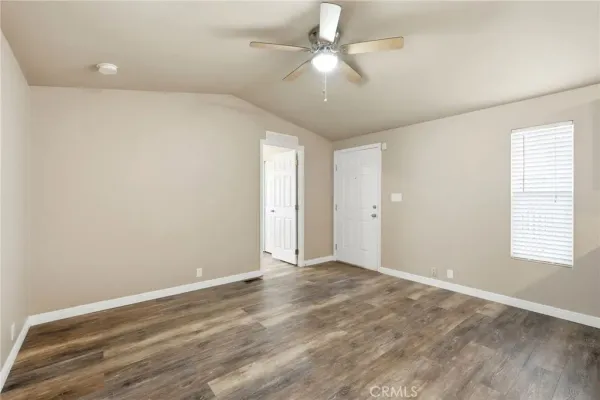 an empty room with fan and windows