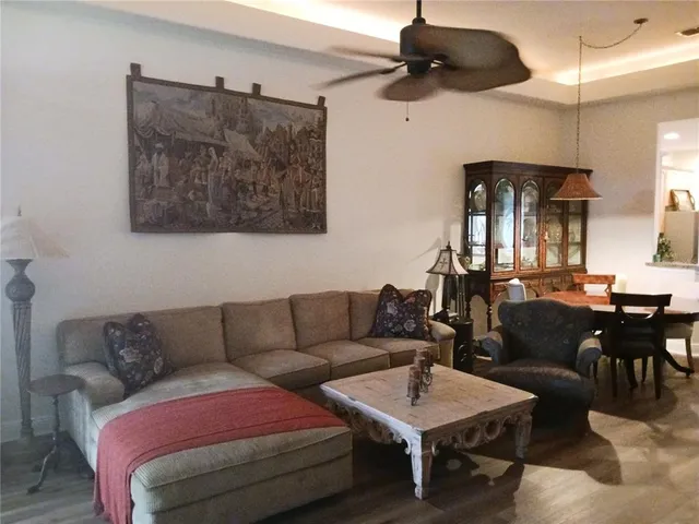 a living room with furniture a ceiling fan and a rug