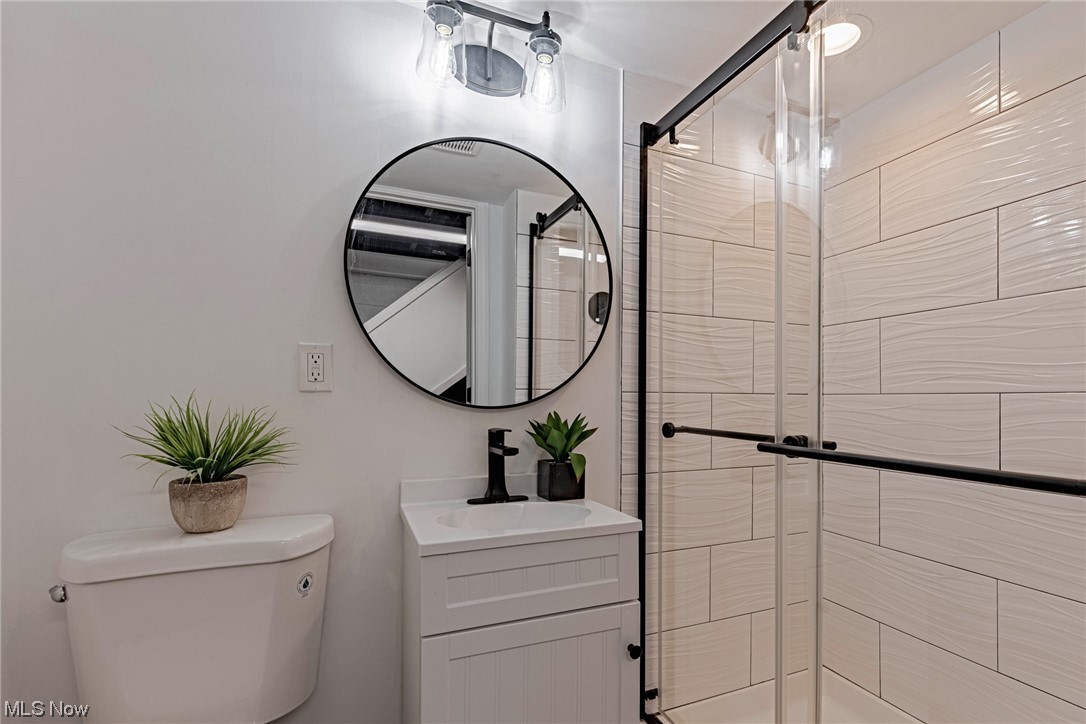 11815 Derby Road Garfield Heights, OH 44125 - Photo 25 of 31 Bathroom featuring an enclosed shower, vanity, and mirror