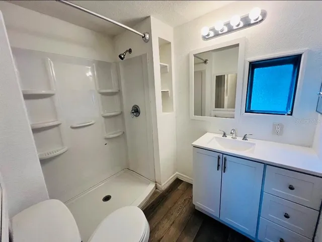 a bathroom with a sink toilet a mirror and shower