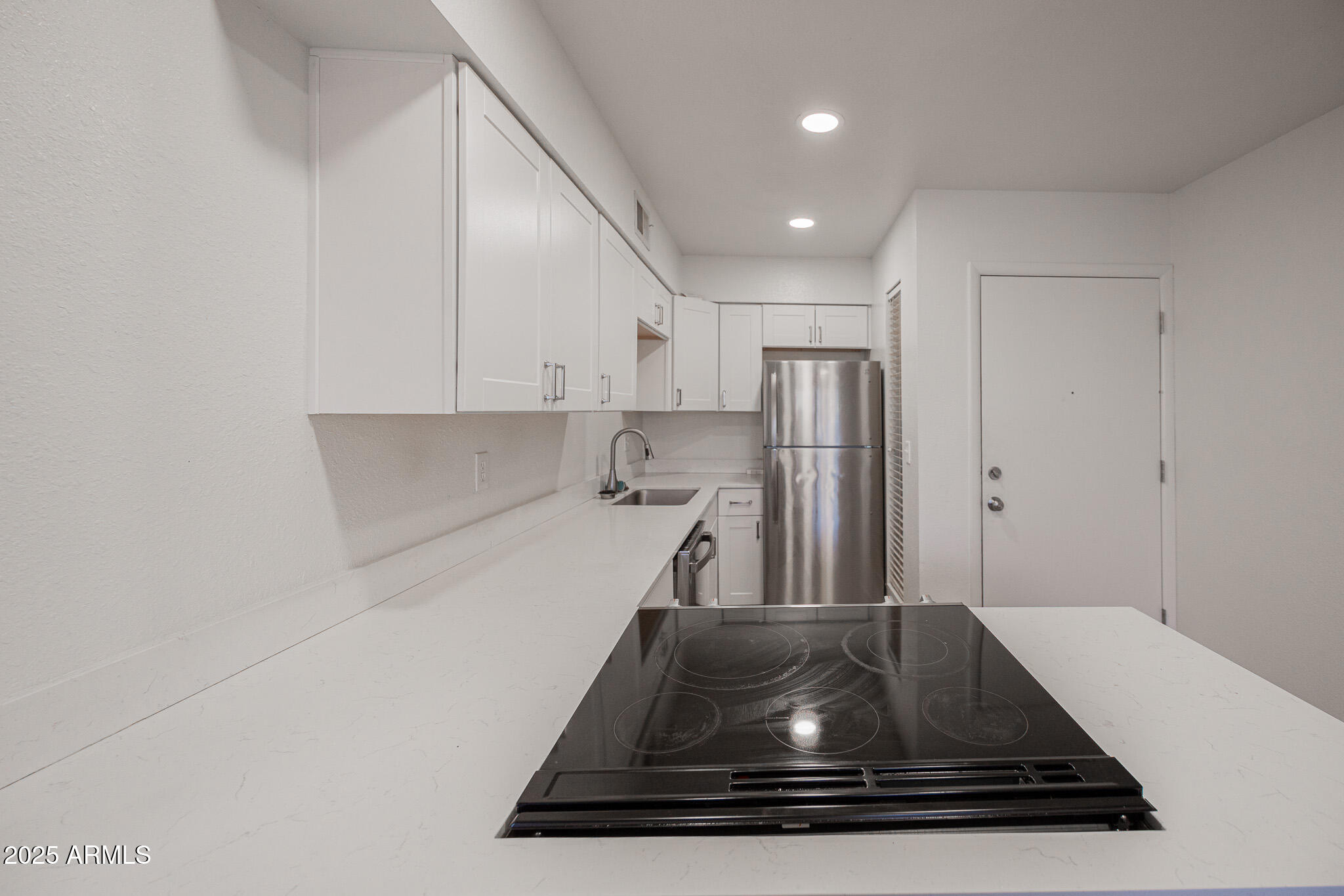 3131 West Cochise Drive, Unit 129 Phoenix, AZ 85051 - Photo 7 of 17 a kitchen with kitchen island a sink stainless steel appliances and white cabinets