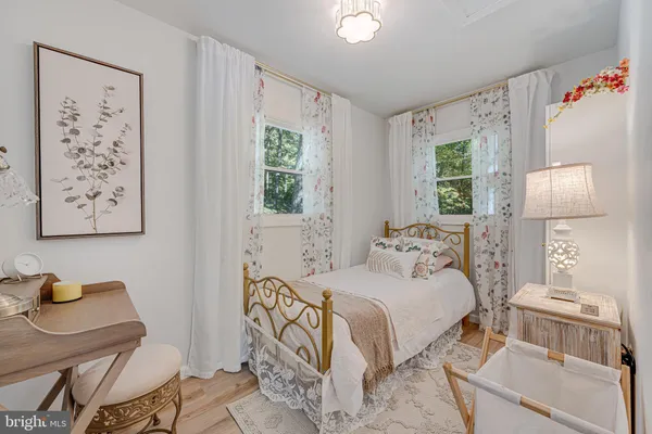 a bedroom with a bed and a table in it with window
