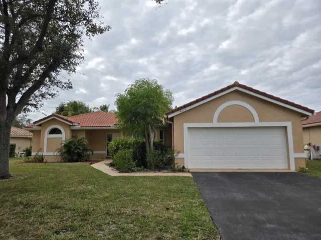 a front view of house with yard and garage