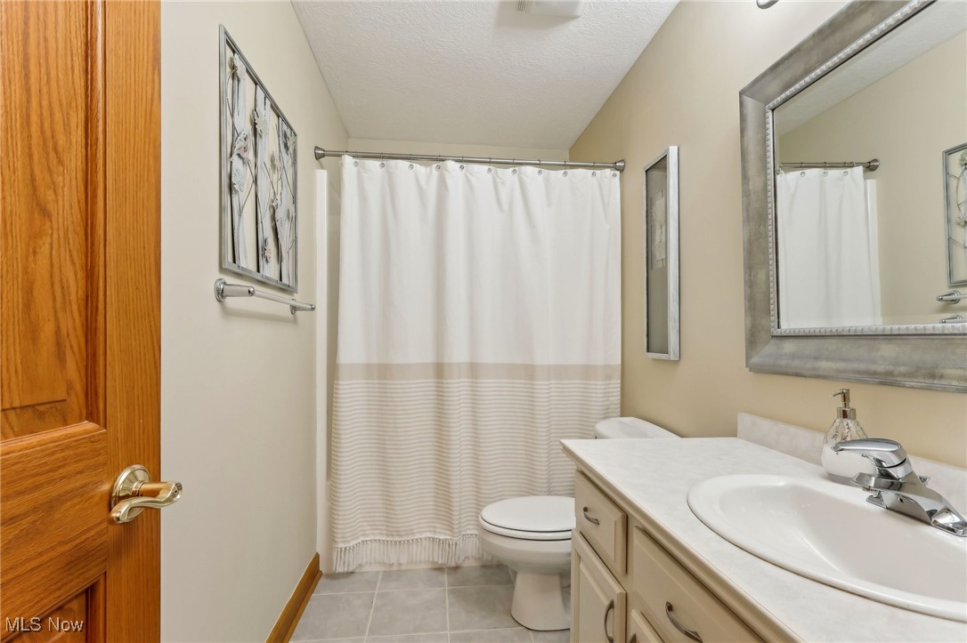3353 Jens Way Perry, OH 44081 - Photo 21 of 49 Bathroom with walk in shower, toilet, a textured ceiling, vanity, and tile patterned flooring