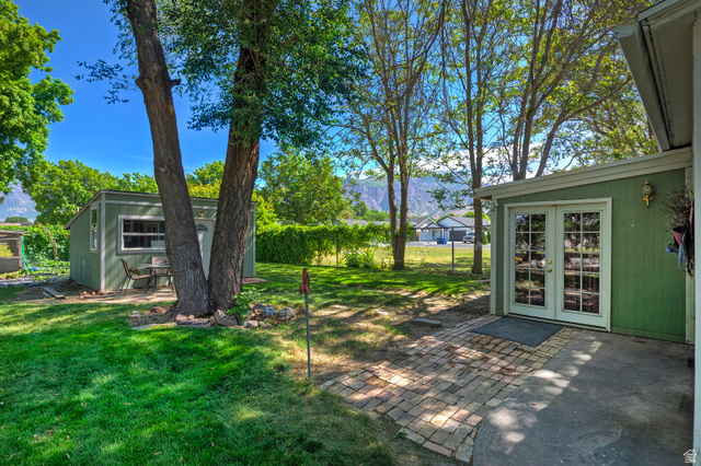 178 17th Street Ogden, UT 84404 - Photo 22 of 29 Expansive backyard featuring a green lawn, mature trees, and a mountain backdrop