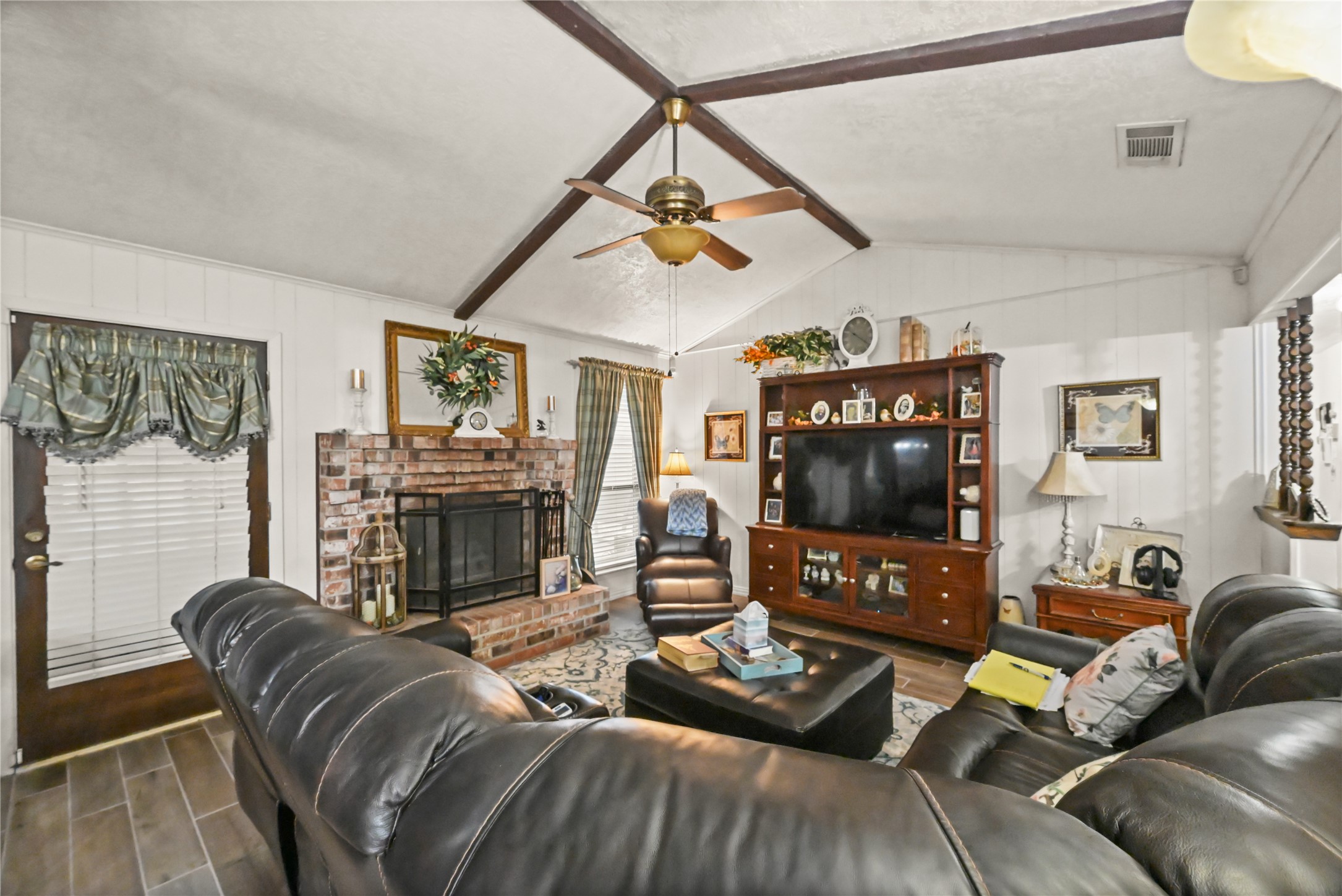 20135 Fox Grove Lane Humble, TX 77338 - Photo 7 of 34 a living room with furniture a fireplace and a flat screen tv