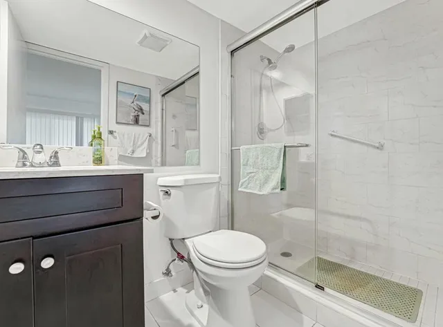 a bathroom with a sink a toilet and shower