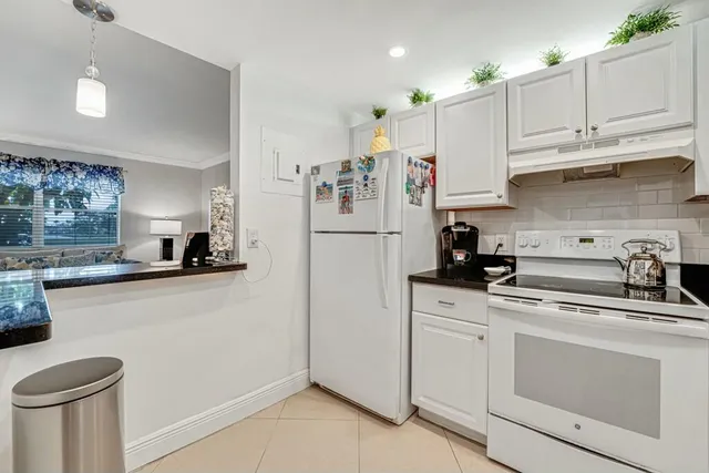 a kitchen with white cabinets and white appliances