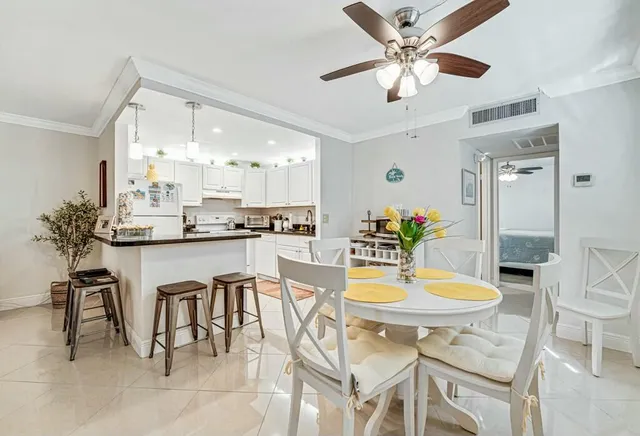 a dining room with stainless steel appliances kitchen island granite countertop a table and chairs