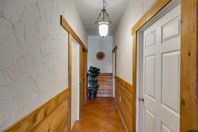 a view of a hallway to a livingroom with furniture