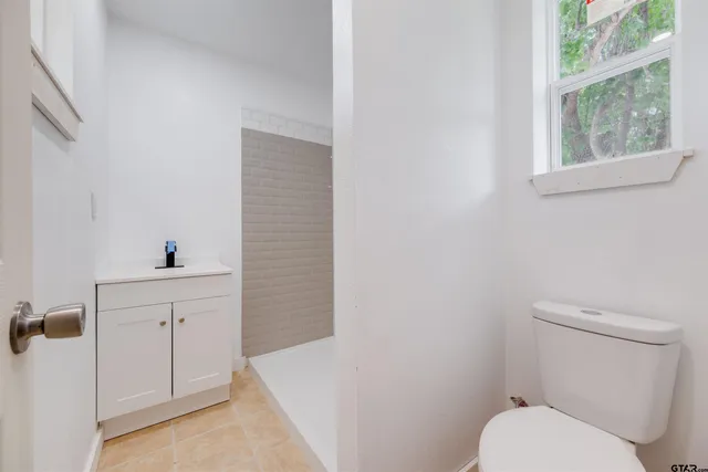 a spacious bathroom with a toilet sink and mirror