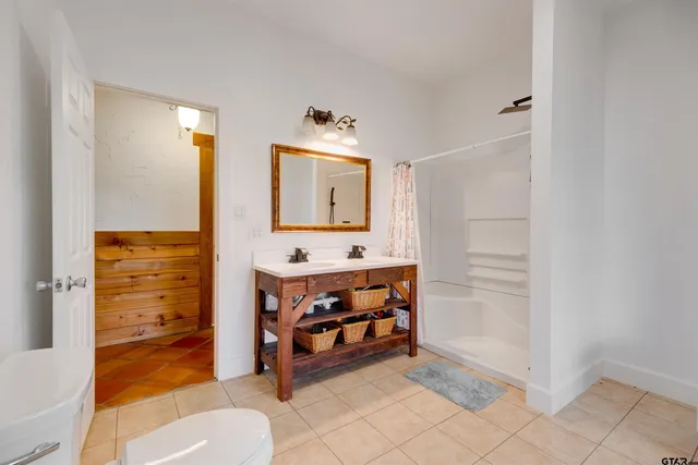 a bathroom with a sink a toilet and shower