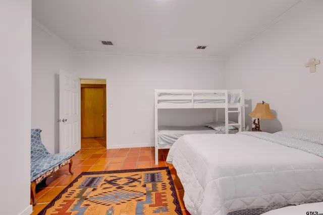 a bedroom with a bed and a lamp on dresser