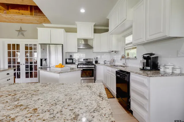 a kitchen with stainless steel appliances granite countertop a stove sink and cabinets