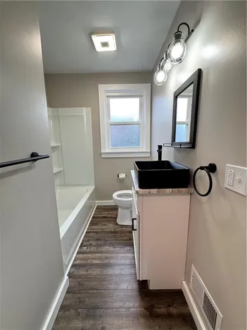 a bathroom with a sink a toilet and a mirror
