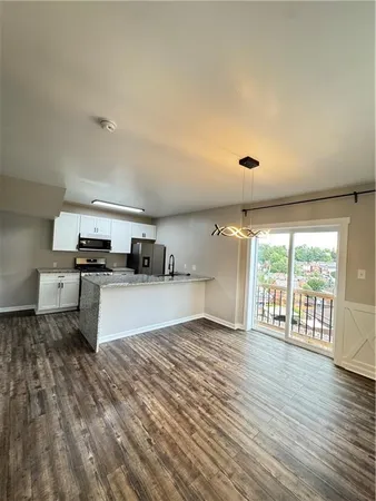 a kitchen with stainless steel appliances granite countertop a stove and a wooden floors